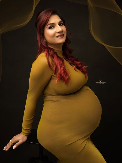 A confident and sassy portrait of a mother-to-be. Her pose and direct gaze capture a modern and empowered vision of pregnancy.
