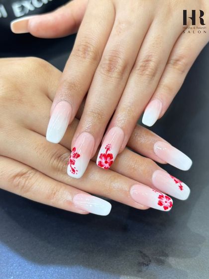 A beautiful and romantic floral nail design. These square-tipped nails feature a soft white ombre base with delicate, hand-painted red hibiscus flowers, ideal for a tropical vacation or a summer wedding.