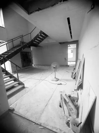 The raw interior of a family lounge in progress, with a temporary staircase and bare walls, hinting at the double-height grandeur to come.