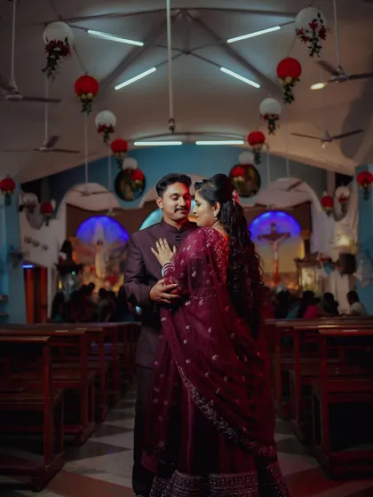 An intimate portrait of a couple during their Catholic wedding reception inside the church. The warm lighting and church pews create a romantic and sacred atmosphere.