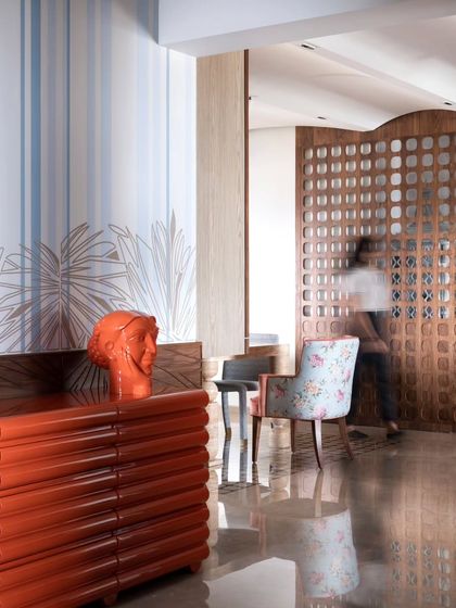 The wallpaper paired with a bold orange console, showcasing a playful mix of color and pattern.