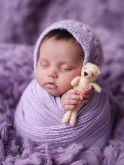 This little one is snuggling a tiny teddy bear while wrapped in a lavender swaddle. I use small, safe props to add a sweet and personal touch.