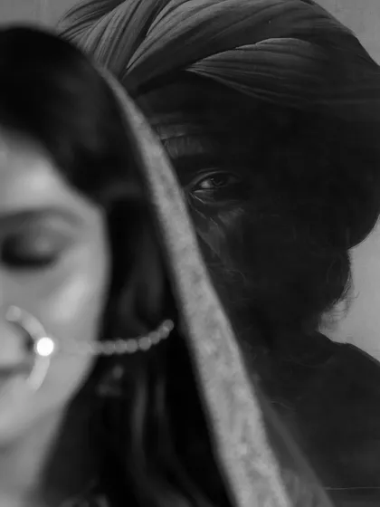 An artistic black and white close-up, focusing on the bride's traditional nath. The shallow depth of field and moody lighting create a powerful, emotive portrait.