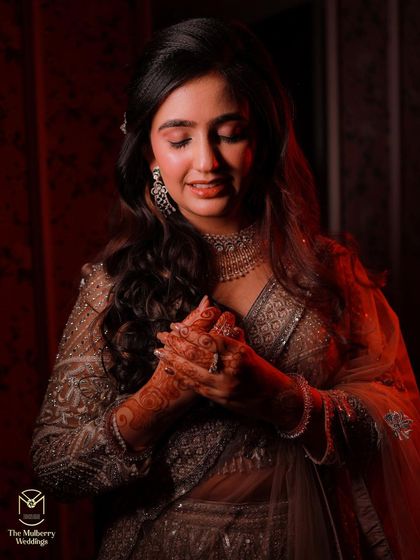 A close-up on the bride's radiant look, highlighting the delicate makeup and henna details.