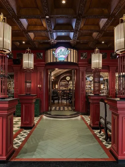 Our platform showcases the best of commercial design, like this bold entrance to 'Sally by 1522' from Studio Camarada. The design reimagines a classic British pub with dramatic red paneling and bespoke lighting, creating an immersive experience for visitors.