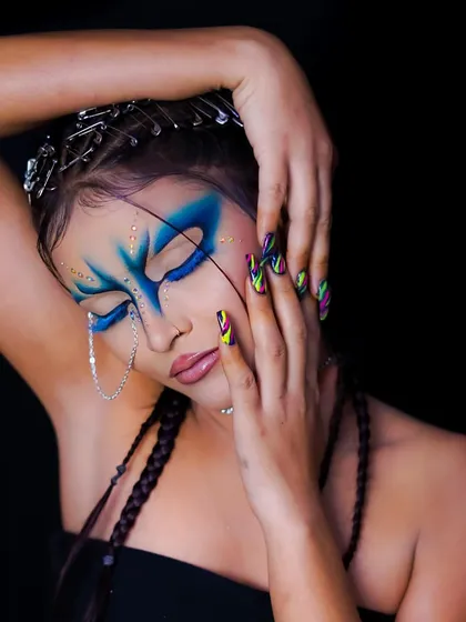 A close-up on the face, showing the intricate blue design and the chain accessory.