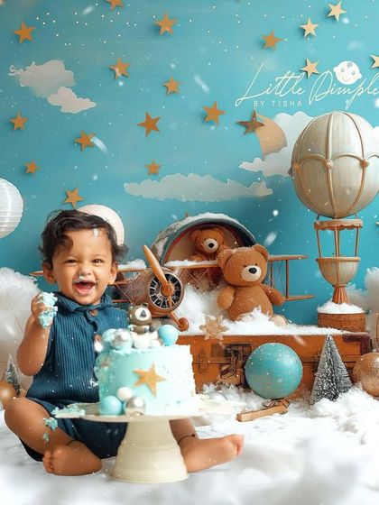 Up, up, and away. This hot air balloon cake smash theme is perfect for your little adventurer, complete with clouds, stars, and a vintage airplane.