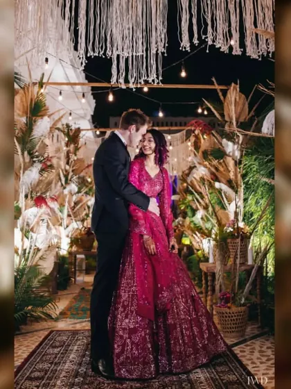 A cozy moment during a "Desert Spice" themed Sangeet. The couple is framed by bohemian decor featuring pampas grass and macrame, creating a warm and intimate atmosphere for their evening celebration.