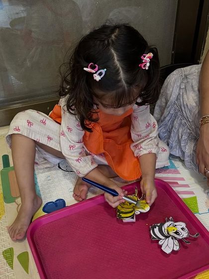A parent and child enjoying the bee painting activity together. I always encourage parents to join in, as it makes the experience even more special for the little ones.