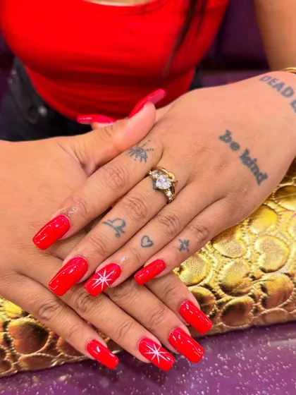 You can never go wrong with a classic, bold red. I use premium gel polish for a high-shine, chip-resistant finish that lasts for weeks. The simple, hand-painted starburst on the ring finger adds a personalized touch to this timeless manicure.