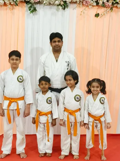 A group of orange belt students from Rejoice International School. Their strong stances and focused expressions show the discipline they have developed through their training.