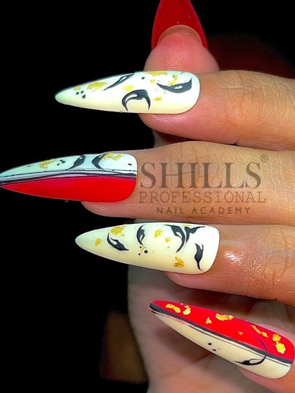 A bold, abstract design combining a red under-nail with black and gold leaf details on a white top.