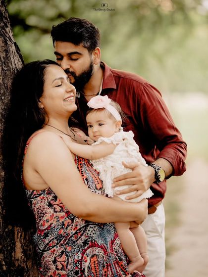 A quiet, candid moment as a father kisses his partner's forehead while she holds their baby. We look for these unscripted displays of affection that tell a powerful story.