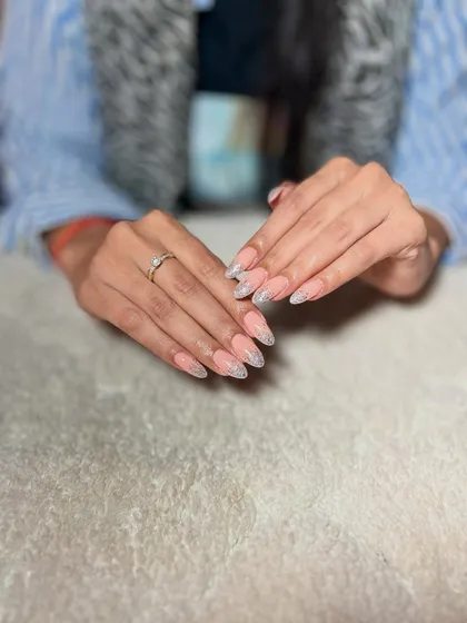 A beautiful glitter fade on almond-shaped nails. The ombre effect with the glitter creates a soft yet glamorous look that is always in demand.
