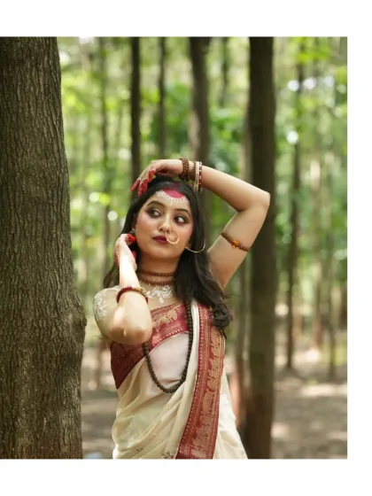 A striking pose in the woods, capturing the divine feminine energy of Parvati with traditional attire, jewelry, and makeup.