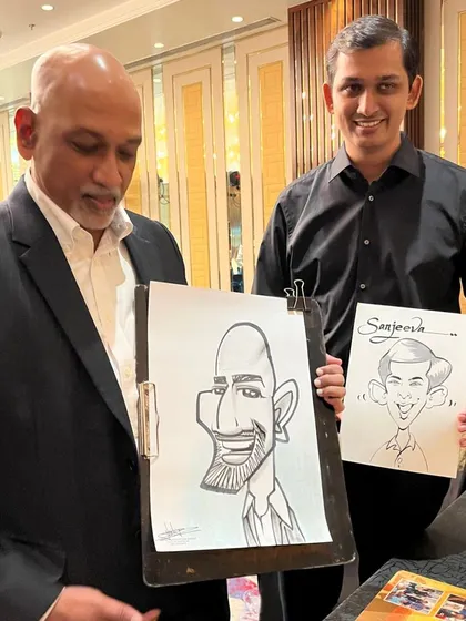 Two guests from the Sheraton party, one holding a caricature of the other.