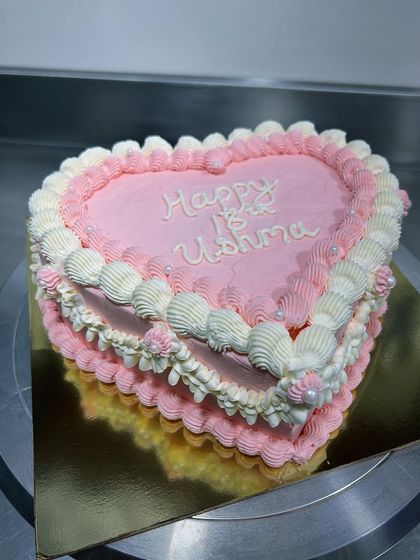 Retro cakes are so much fun! This heart-shaped cake in shades of pink and white features beautiful, detailed piping work that gives it a classic, romantic feel.