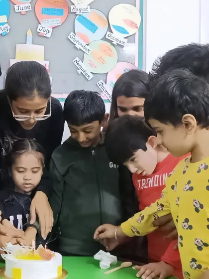 A group of children eagerly watch as the birthday cake is cut. These shared experiences are essential for building a sense of community.