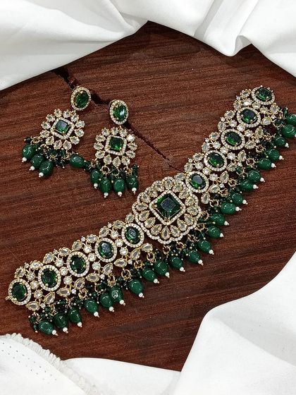 A versatile choker set available in multiple colors including white pearl, ruby, emerald, and pastel pink. The design features a central square motif with hanging beads, making it a popular choice for various festive occasions.