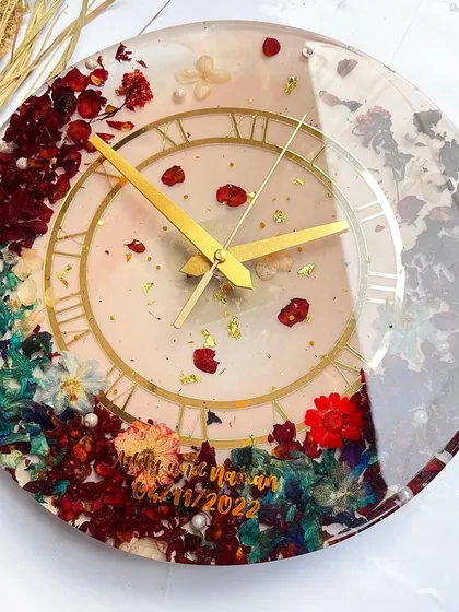 This clock is a beautiful mix of colors and textures. The preserved hydrangeas, roses, and other flowers create a stunning floral border on a clear resin base.