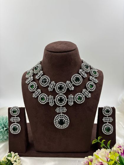 This bold, silver-plated AD set features large circular motifs. It's a statement piece available in sapphire blue, emerald green, ruby red, and all-white, perfect for customers who want to stand out.
