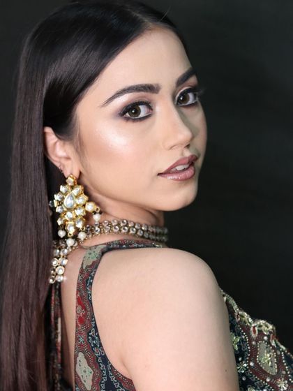 A three-quarter view of the cut-crease look, highlighting the cheekbone glow and elegant jewelry.