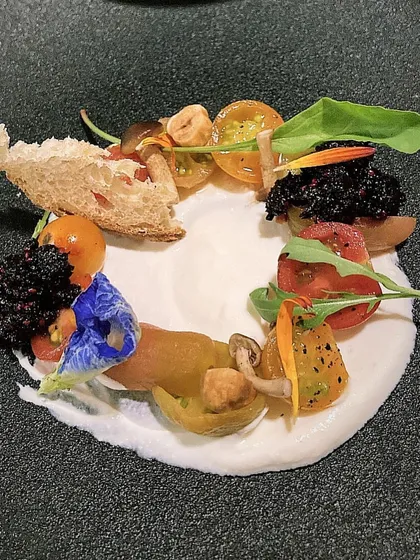 A deconstructed salad with heirloom tomatoes, burrata, and black olive "caviar". A fresh and modern take on a caprese salad.