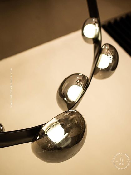 An unconventional design where smoked glass ovals are cradled by a flexible black leather strap. This fixture combines hard and soft textures for a uniquely modern and minimal aesthetic, perfect for creating a talking point in any room.