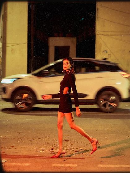 An urban, on-the-move shot from the student's test shoot. The motion blur of the car contrasts with the model's confident stride, adding a dynamic element to the photo.