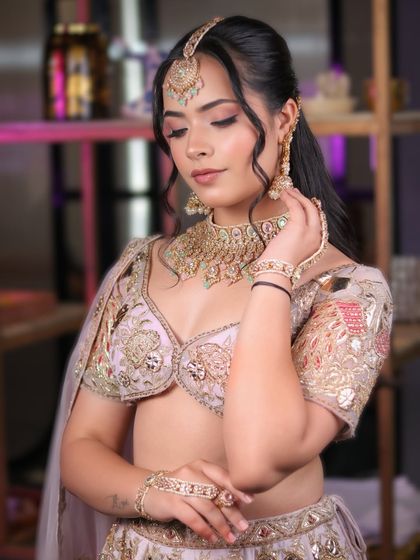 This graceful and traditional look features soft pink eyeshadow and a flawless base, paired with a beautiful pastel lehenga and kundan jewelry.