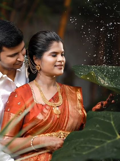 A creative couple's shot taken during an outdoor maternity session. The husband looks on lovingly as his wife interacts with nature, creating a romantic and artistic portrait.