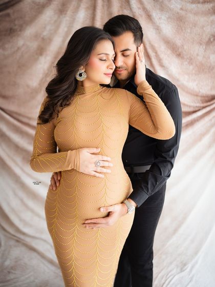 An intimate and loving embrace. The warm tones of the background and the mamma's dress create a very cozy and romantic atmosphere.