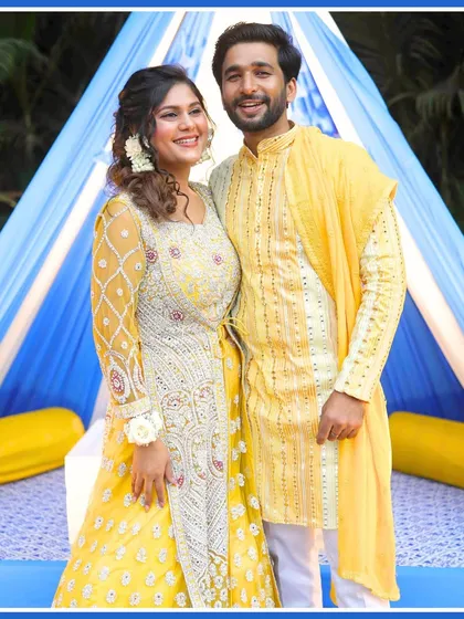 A happy portrait of the couple, perfectly coordinated in their yellow outfits, matching the Haldi theme.