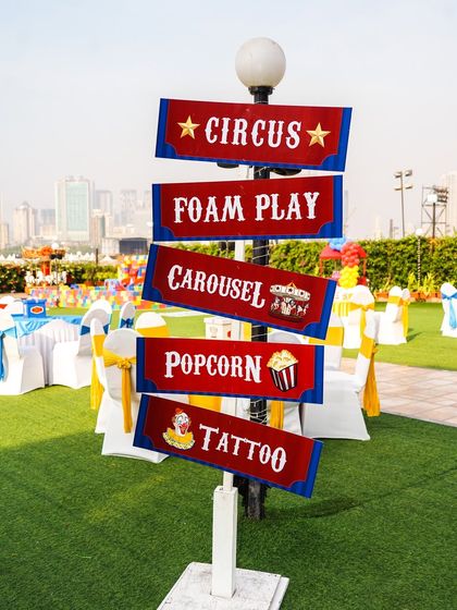 A themed signpost directing guests to all the fun activities, including the circus, foam play, carousel, and more.
