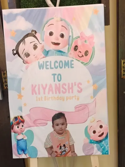 A personalized welcome easel sign for a Cocomelon themed first birthday party, featuring a photo of the birthday boy.