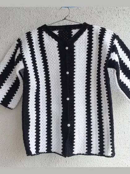 A classic black and white striped shirt, custom-made with a V-neck and button-front. This is a timeless piece that can be styled in countless ways.