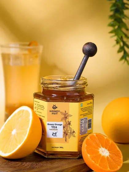 A jar of honey orange tea concentrate with fresh oranges and a glass of iced tea. This shot communicates the product's refreshing flavor and is perfect for summer promotions.