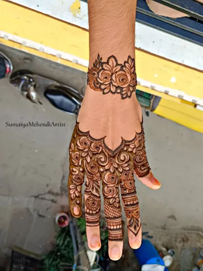 A simple and elegant design with a rose cuff and a beautiful pattern covering the back of the hand.