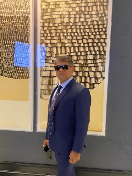 A client stands confidently in his custom navy blue suit. The impeccable fit and classic design make it a cornerstone of a powerful and stylish wardrobe.