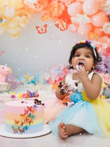 This little girl is getting right into her colorful first birthday cake during her smash session.