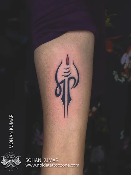 A minimalist and creative "Maa Paa" tattoo. This design stylistically combines the Devanagari script for mother and father into a single, unified symbol.