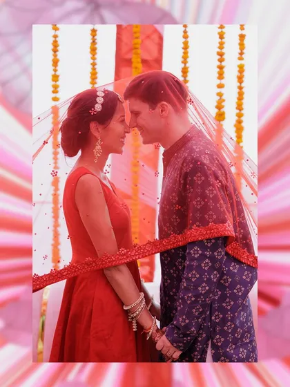 An intimate portrait of the couple under the bride's red veil. This shot symbolizes their union, bringing them together in a shared space of love and tradition.