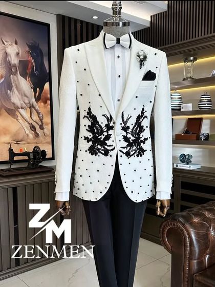 A stunning white tuxedo jacket with black pearl detailing and bold black floral embroidery. This piece combines classic colors with artistic, high-contrast design elements.