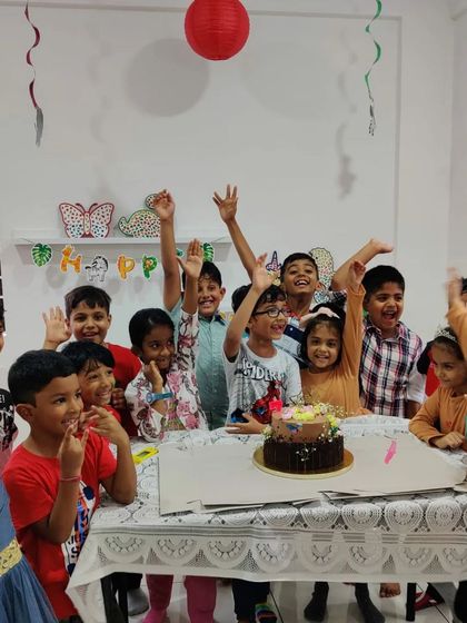 Hooray for the birthday boy! A group of excited kids celebrating together after a fun and messy art activity at the studio.