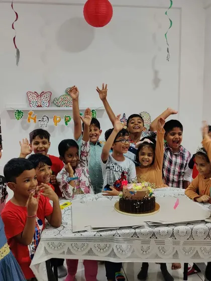 Hooray for the birthday boy! A group of excited kids celebrating together after a fun and messy art activity at the studio.