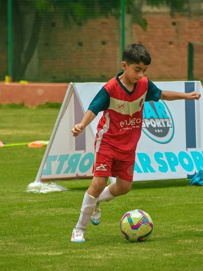 A young player focuses on the ball, preparing for his next move in the game.