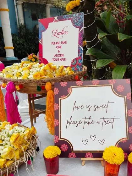 We love designing creative and traditional guest favors. This welcome setup for a Haldi ceremony features baskets of fresh gajra for the ladies to adorn their hair, adding a fragrant and interactive element to the celebration.