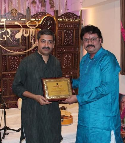 It is our privilege to honor the artists who share their gift with us. Here, we are presenting an award to a slide guitar maestro.