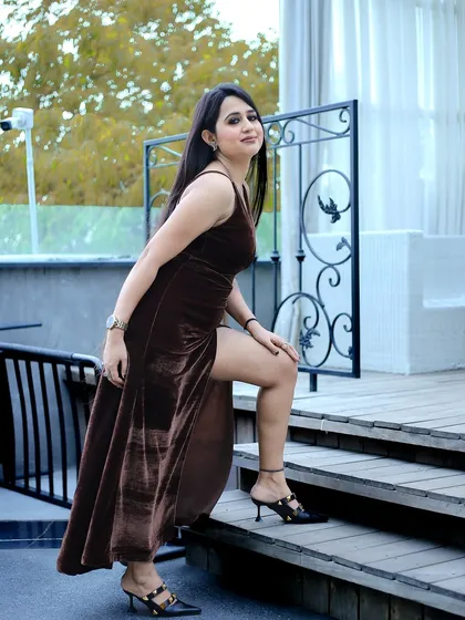 A full-length shot from the same influencer session, showing the complete outfit. The pose on the stairs adds a dynamic element, highlighting the dress and shoes effectively for a fashion post.