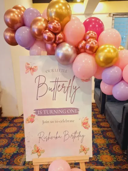 A personalized welcome sign for the "Little Butterfly" turning one, complete with a matching balloon garland. It's these details that make a party feel complete.